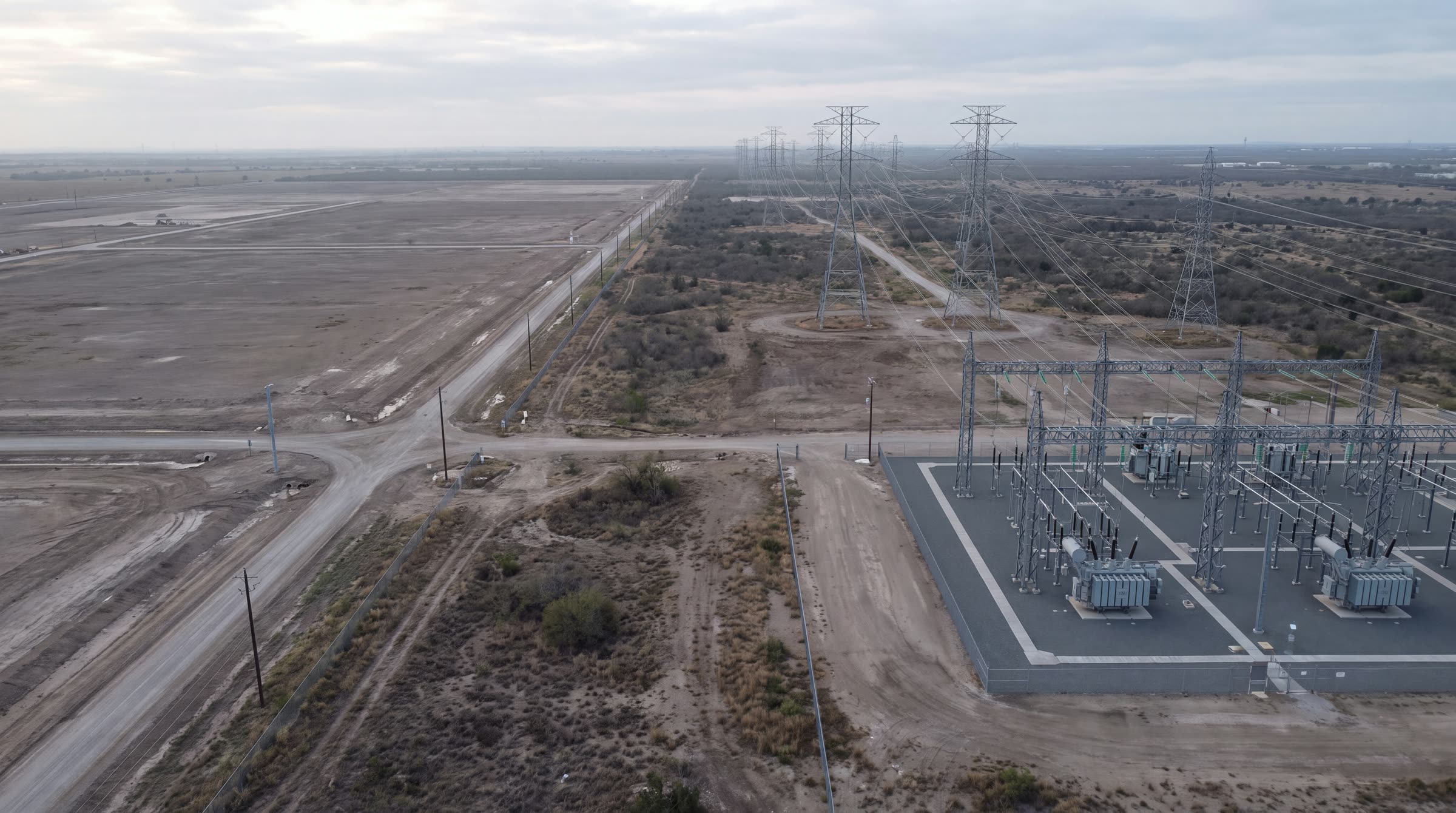 Conceptual aerial view of electrical infrastructure beside undeveloped land.